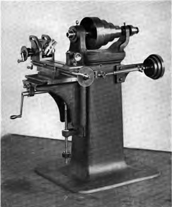 Photograph of an early Brown & Sharpe universal milling machine: a cone pulley spindle on a column, a swivelling table with an index head, and a knee raised by a screw.